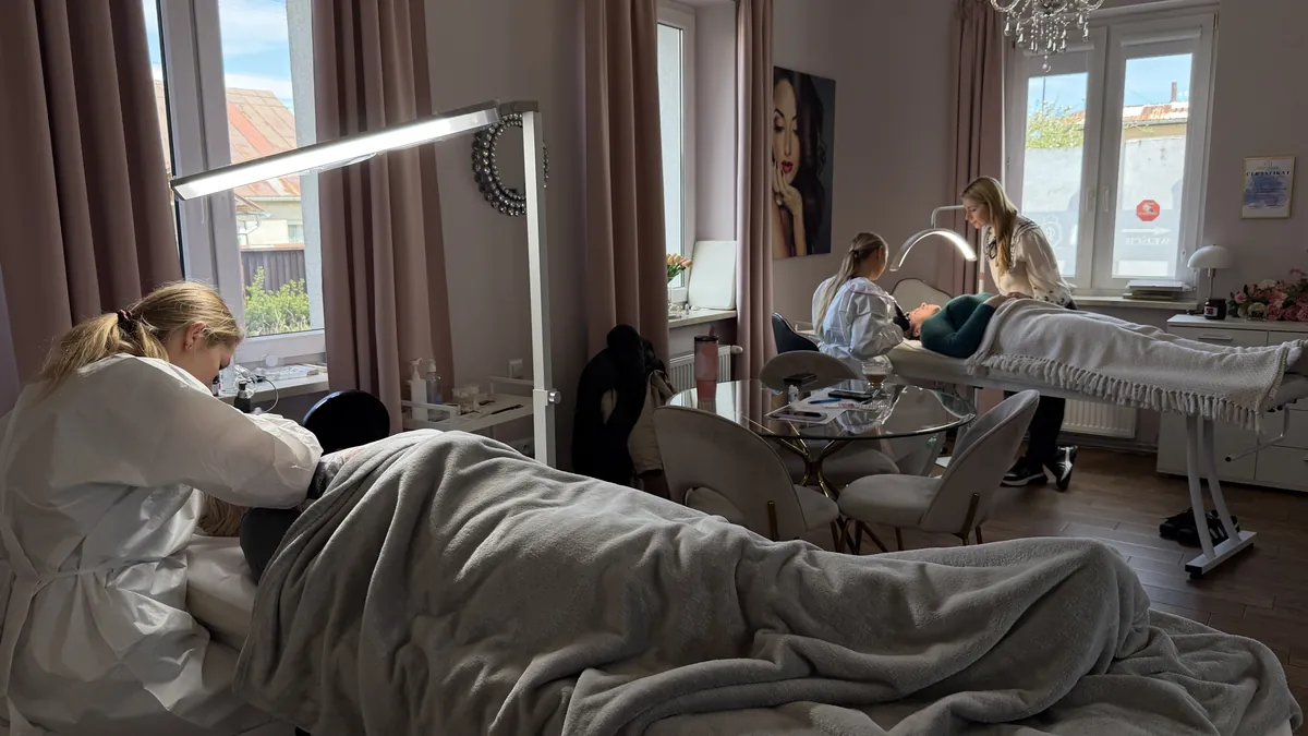 Dwie kursantki pracują jednocześnie na modelkach w salonie